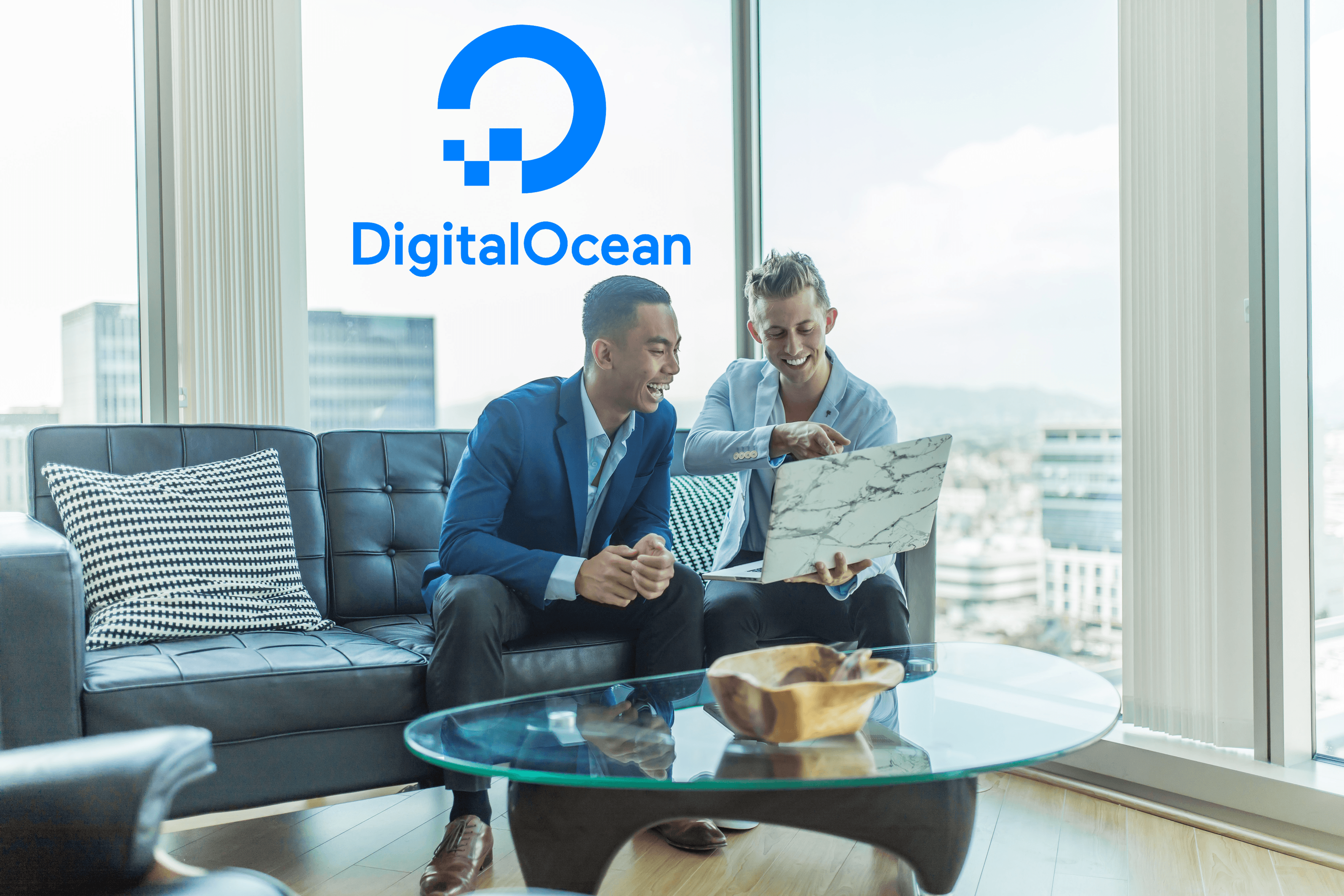 Businessmen happily discussing business stats on laptop with DigitalOcean logo on top