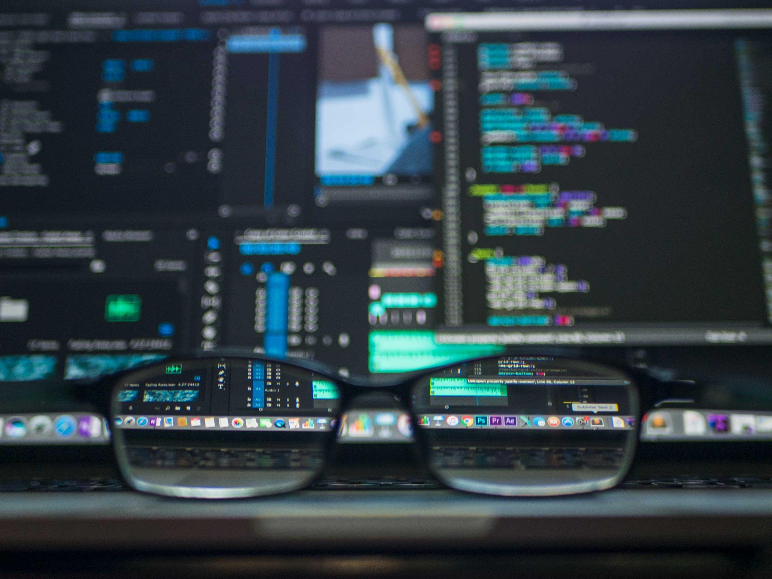 Glasses in front of software quality testing data on computer screen